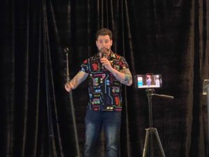 Peter Laneas, on-stage delivering comedy